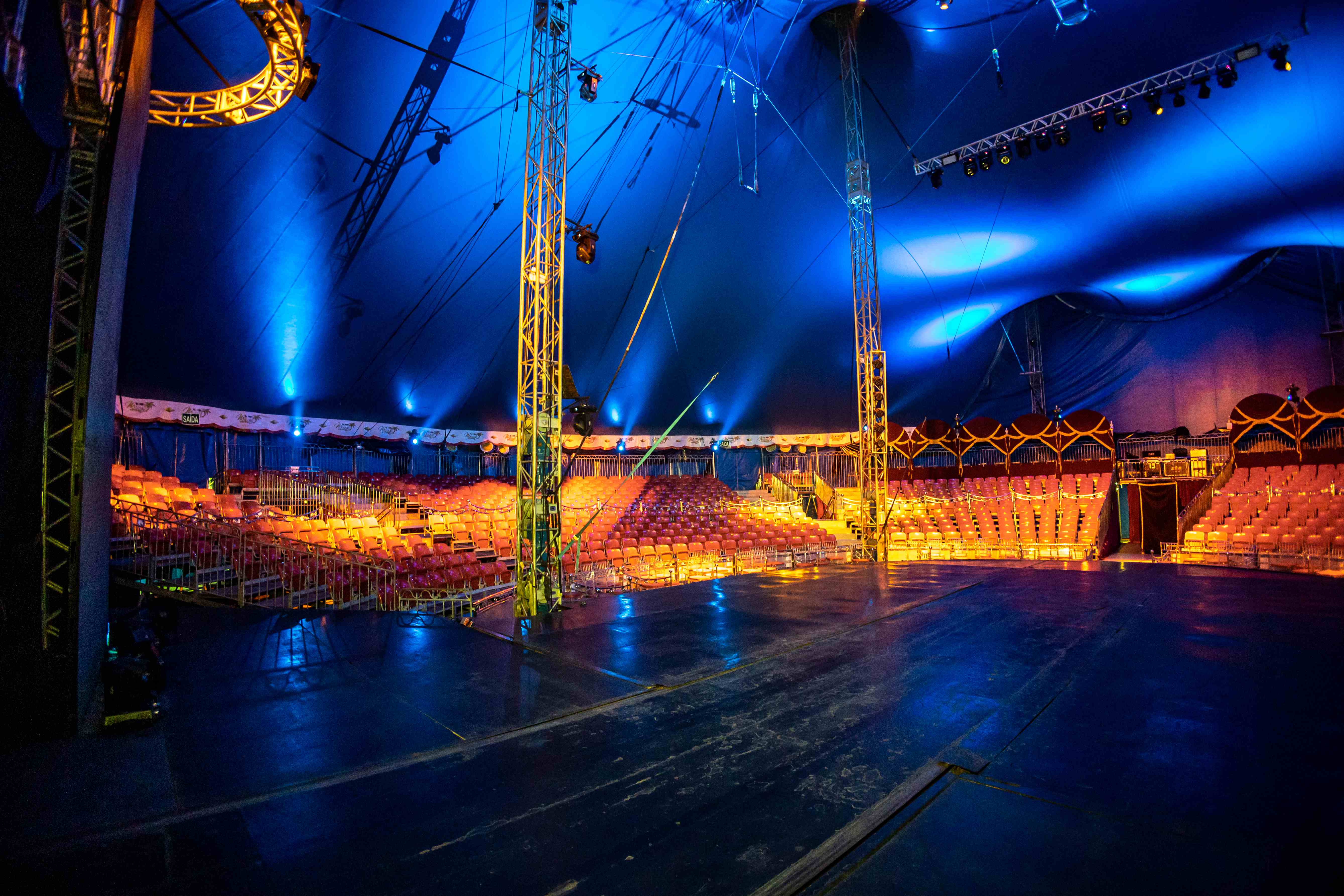 Interior do picadeiro com iluminação dourada e azul