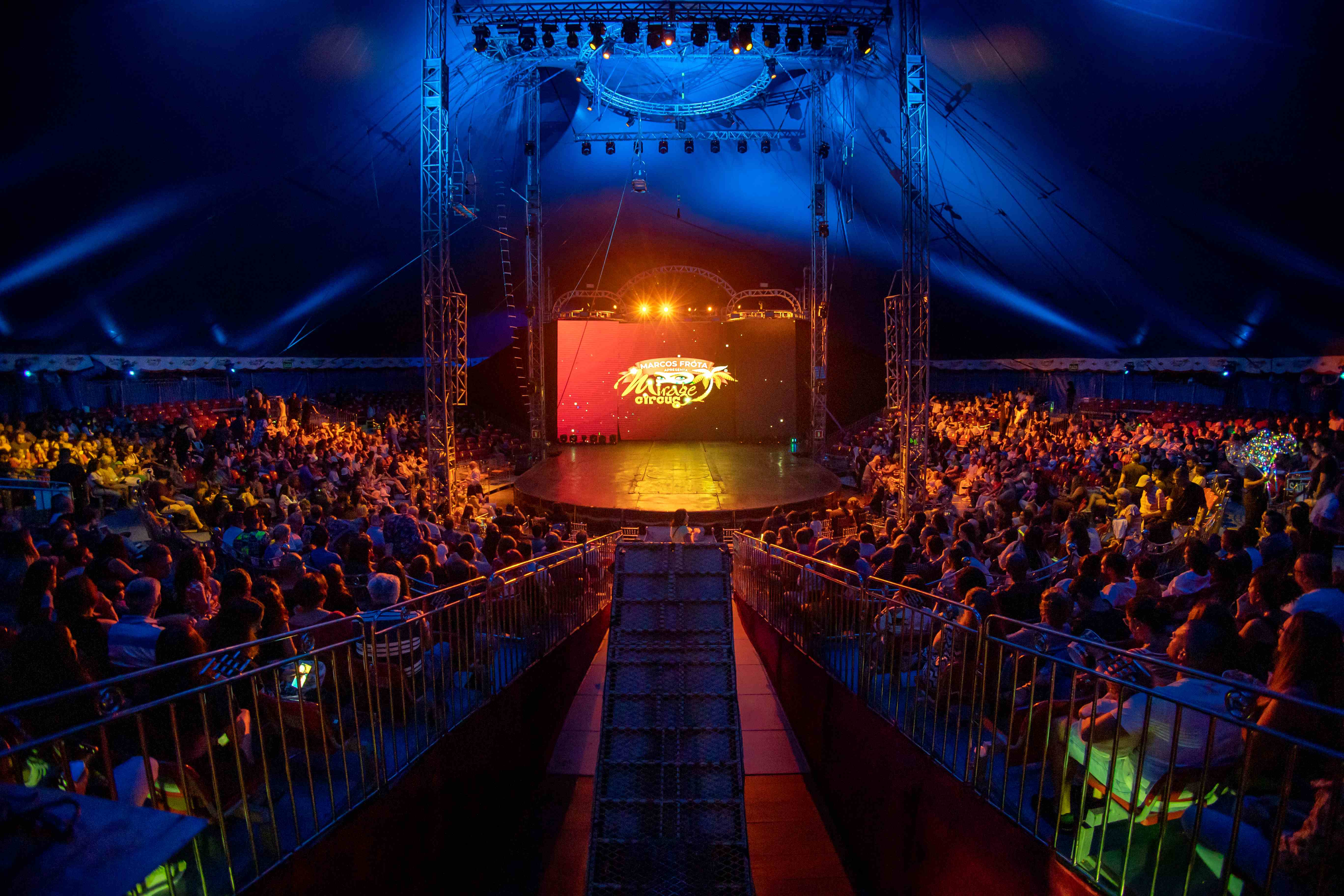 Picadeiro lotado durante o espetáculo com logo do Mirage